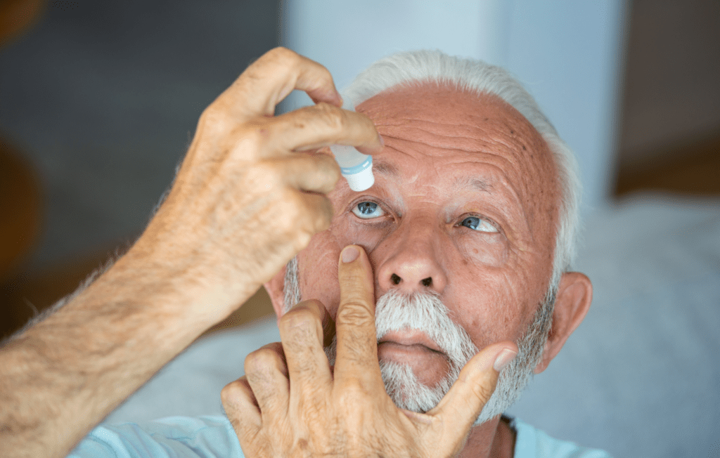 elderly man putting customised eye drops in his eye